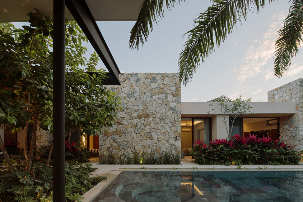 Diseño en l que agrupa los servicios y la zona privada en un ala lateral,